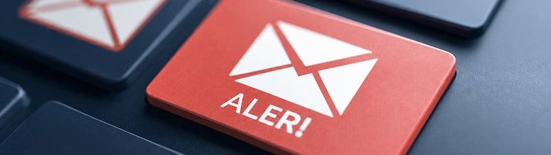 A red email alert button surrounded by dark envelope icons, symbolizing email security threats.